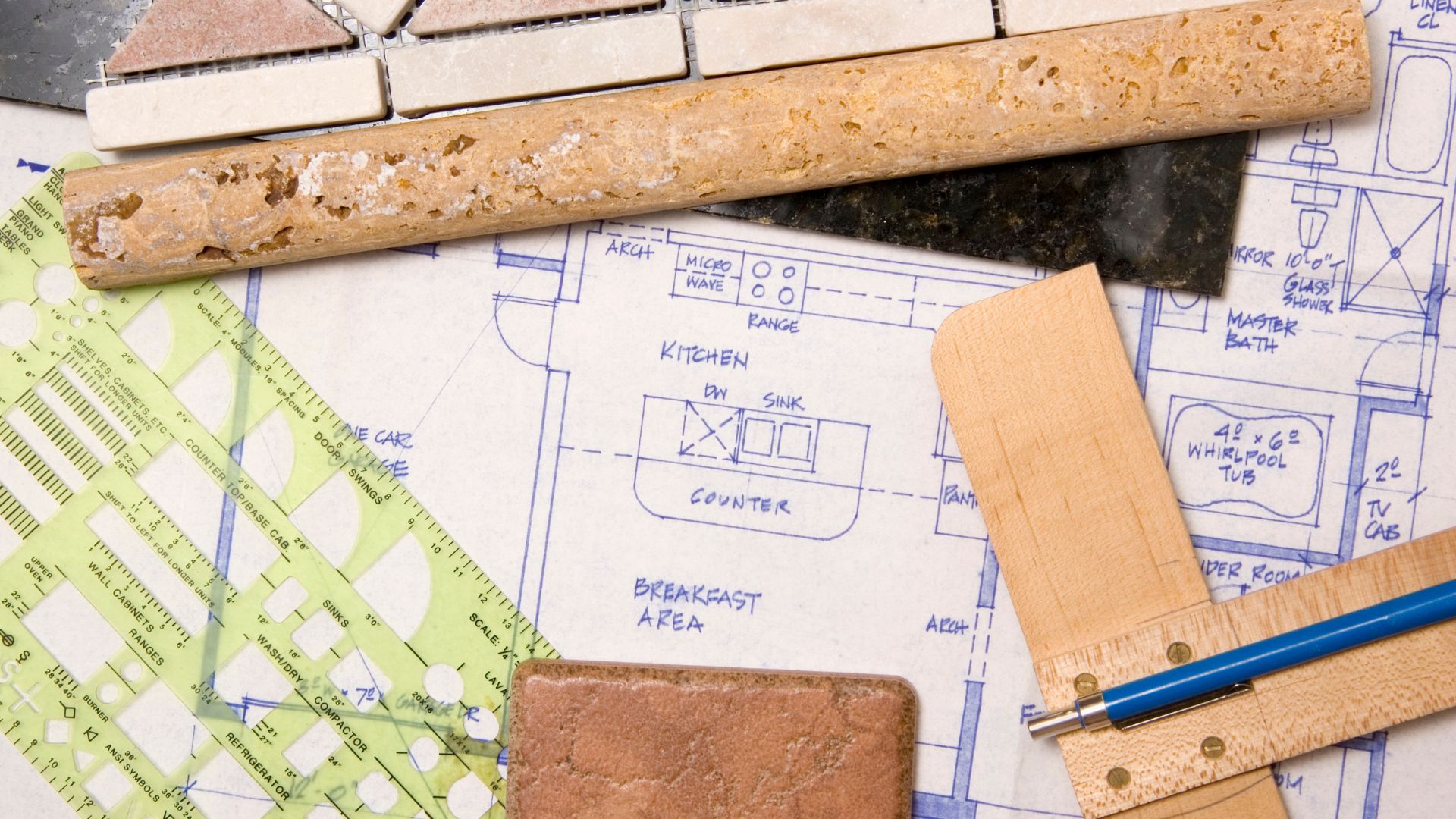 Blueprints for a luxury home remodeling project, surrounded by rulers and tools.